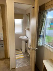 a small bathroom with a sink and a window at 230 Unity Holiday Resort 6 Birth cosy and secure property next to all shops and entertainment passes optional in Brean +40 photos