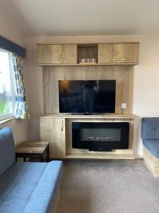 a living room with a large flat screen tv at 230 Unity Holiday Resort 6 Birth cosy and secure property next to all shops and entertainment passes optional in Brean