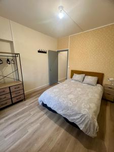a bedroom with a large bed and a dresser at Duplex spacieux-2chambres-ideal vehicule electrique in Melle