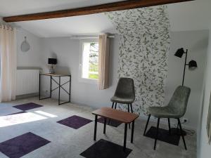 a living room with two chairs and a table at L'Orée du Puy in Les Herbiers