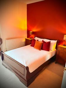 a bedroom with a large bed with red walls at Swan Hotel Forton in Forton