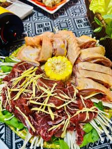 a plate of food with meat and vegetables on a table at Homestay Mường Lay in Bản Pong
