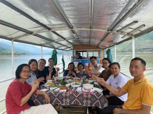 a group of people sitting around a table eating food at Homestay Mường Lay in Bản Pong