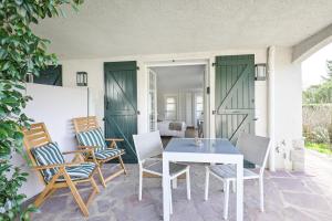 a patio with a table and chairs on a porch at Golfetmer in Saint-Jean-de-Luz