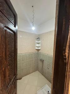 a bathroom with a shower with a toilet and a light at chitoui in Ben Slimane +7 photos