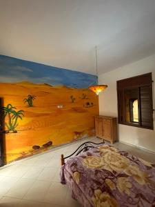 a bedroom with a large painting on the wall at chitoui in Ben Slimane