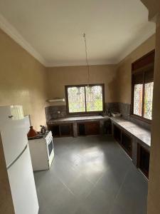 an empty kitchen with a refrigerator and a stove at chitoui in Ben Slimane
