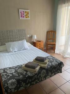 a bedroom with a bed with towels on it at Hotel Move Espadan in Azuébar