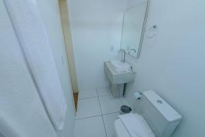 a white bathroom with a toilet and a sink at Pousada Prime Gramado in Gramado +20 photos