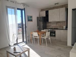 a kitchen with a table and chairs in a room at Il Nido di Chiara 2 in Formia +11 photos