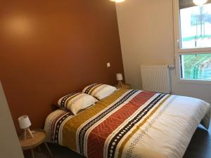 a bedroom with a bed with two pillows and a window at Appartement récent et à la déco moderne in Damgan