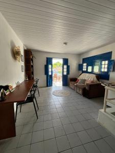 a living room with a table and a couch at Canto da Ita - Próxima a praia com piscina e churrasqueira in Itamaracá