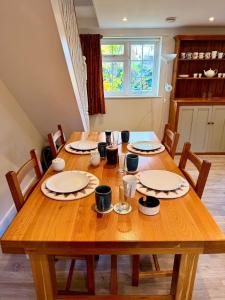 a wooden table with plates and bowls on it at Cosy stay within South Downs! in Southampton +1 photo