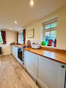 a kitchen with a wooden counter top and two windows at Cosy stay within South Downs! in Southampton