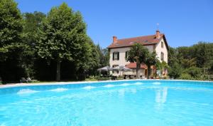 a large swimming pool in front of a house at Renard et l'abeille in Chalmoux