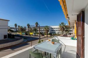 a table and chairs on a balcony with a view of a street at YourHouse Llimonera in Port de Pollensa