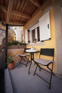 a patio with two chairs and a table on a balcony at Pearl Port House in Ágios Rókkos
