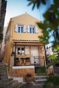 a yellow house with a table in front of it at Pearl Port House in Ágios Rókkos