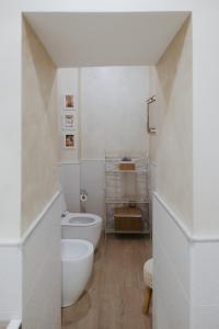 a white bathroom with a toilet and a sink at La Loggia Del Popolo in Ascoli Piceno
