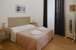 a bedroom with a bed with two towels on it at La Loggia Del Popolo in Ascoli Piceno +8 photos