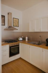 a kitchen with white cabinets and a sink at La Loggia Del Popolo in Ascoli Piceno