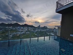 a rooftop swimming pool with a view of a city at Plus Sriracha Condo NEW Building in Si Racha