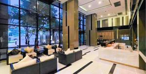 a large lobby with couches and a large window at Plus Sriracha Condo NEW Building in Si Racha
