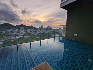 a swimming pool with a view of a city at Plus Sriracha Condo NEW Building in Si Racha