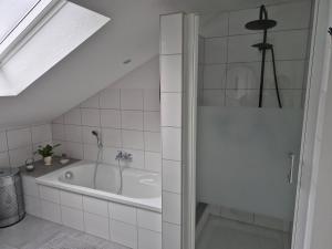 a bathroom with a bath tub and a sink at Casa-Mandelartz in Rees