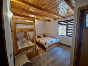 two bunk beds in a room with wooden ceilings at Cabana Valea Bradului in Nucşoara