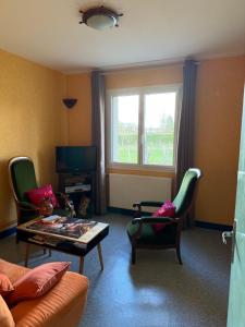 a living room with a couch and a table and chairs at Appartement indépendant chez l'habitant in Cholet