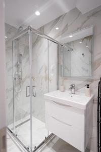 a white bathroom with a shower and a sink at Pearl Port House in Ágios Rókkos +24 photos