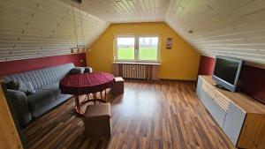 a living room with a couch and a television at Ferienwohnung Lippewiesen in Lippetal +2 photos