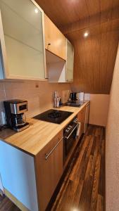 a kitchen with wooden cabinets and a stove top oven at Ferienwohnung Lippewiesen in Lippetal