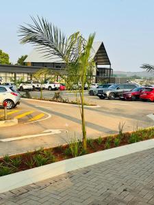 a parking lot with a palm tree in a parking lot at The Legacy Hotel and Spa in Tzaneen