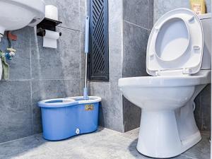 a bathroom with a toilet and a blue trash can at SympaHome in Kiambu +13 photos