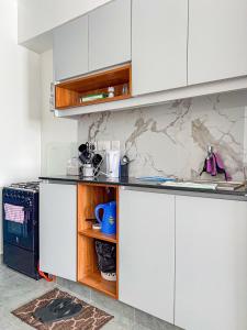 a kitchen with white cabinets and a counter at SympaHome in Kiambu