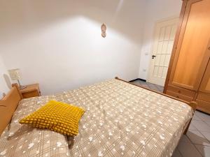 a bedroom with a bed with a yellow pillow on it at La Piccola Dimora Sul Mare in Gallipoli