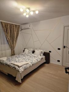 a bedroom with a bed with a geometric wall at Studio Maria in Bucharest
