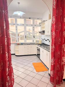 a kitchen with red curtains and a large window at La Piccola Dimora Sul Mare in Gallipoli +18 photos