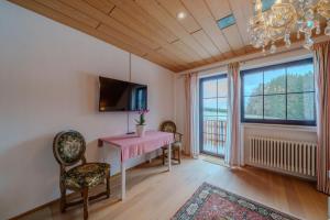 a dining room with a pink table and chairs and a window at Adlerhorst in Bad Wörishofen