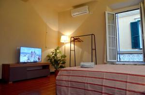 a bedroom with a bed and a flat screen tv at Ca' di Beppe in Albenga +21 photos