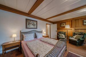 a bedroom with a large bed and a chair at Adlerhorst in Bad Wörishofen