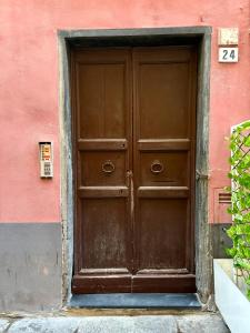 a large wooden door on a pink building at Ca' di Beppe in Albenga