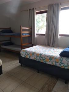 a bedroom with a bed and a window at Casarão Pertinho da Praia in Bertioga +49 photos