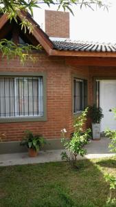 Una casa de ladrillo con dos ventanas y una puerta en La Casita de Sil en Mina Clavero