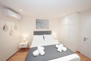 a white bedroom with a large bed with white pillows at Pearl Port House in Ágios Rókkos