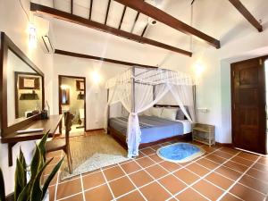 a bedroom with a canopy bed in a room at MAYA Ahangama in Ahangama