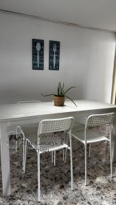 a white table with two chairs and a potted plant at apartamento thecanarys 1 in Santa Rosa de Cabal