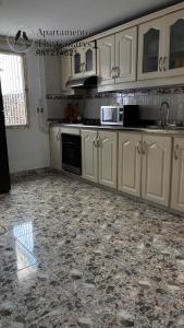 a kitchen with white cabinets and a marble floor at apartamento thecanarys 1 in Santa Rosa de Cabal +2 photos